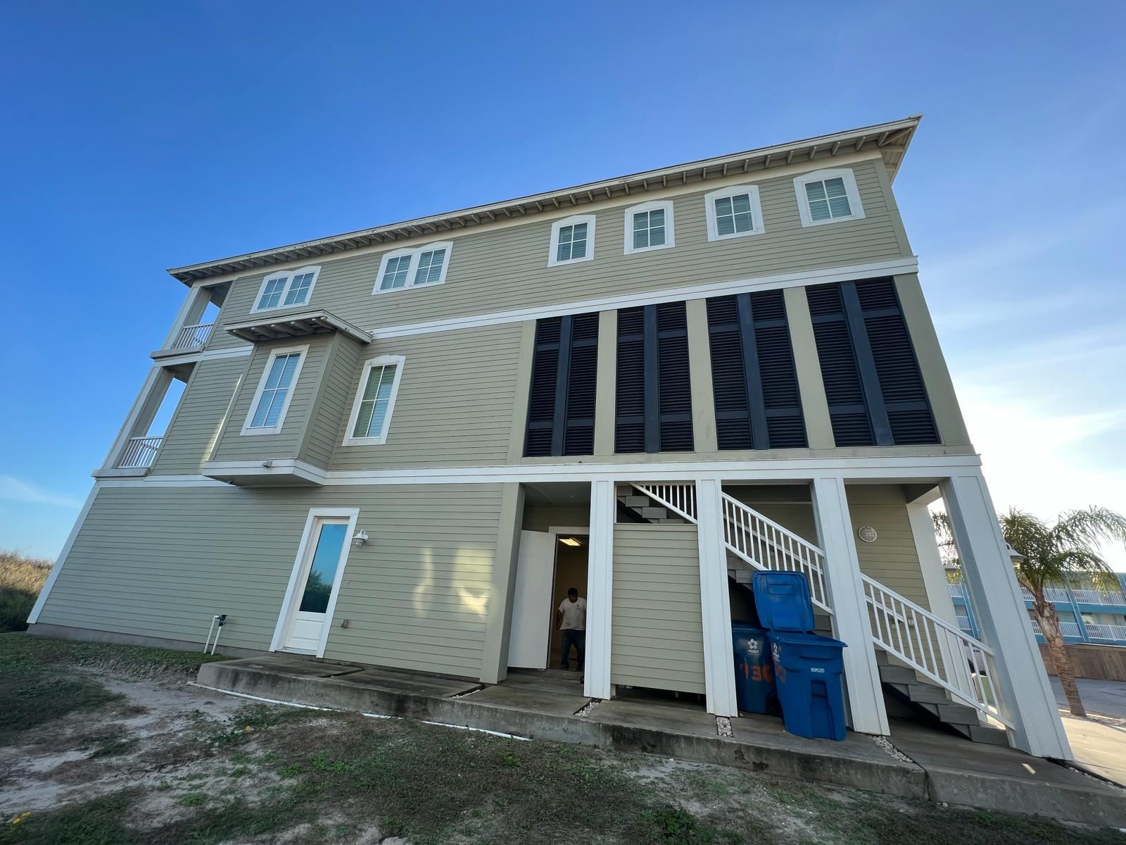 Cream coastal home with solar panels built by OP Construction & Development