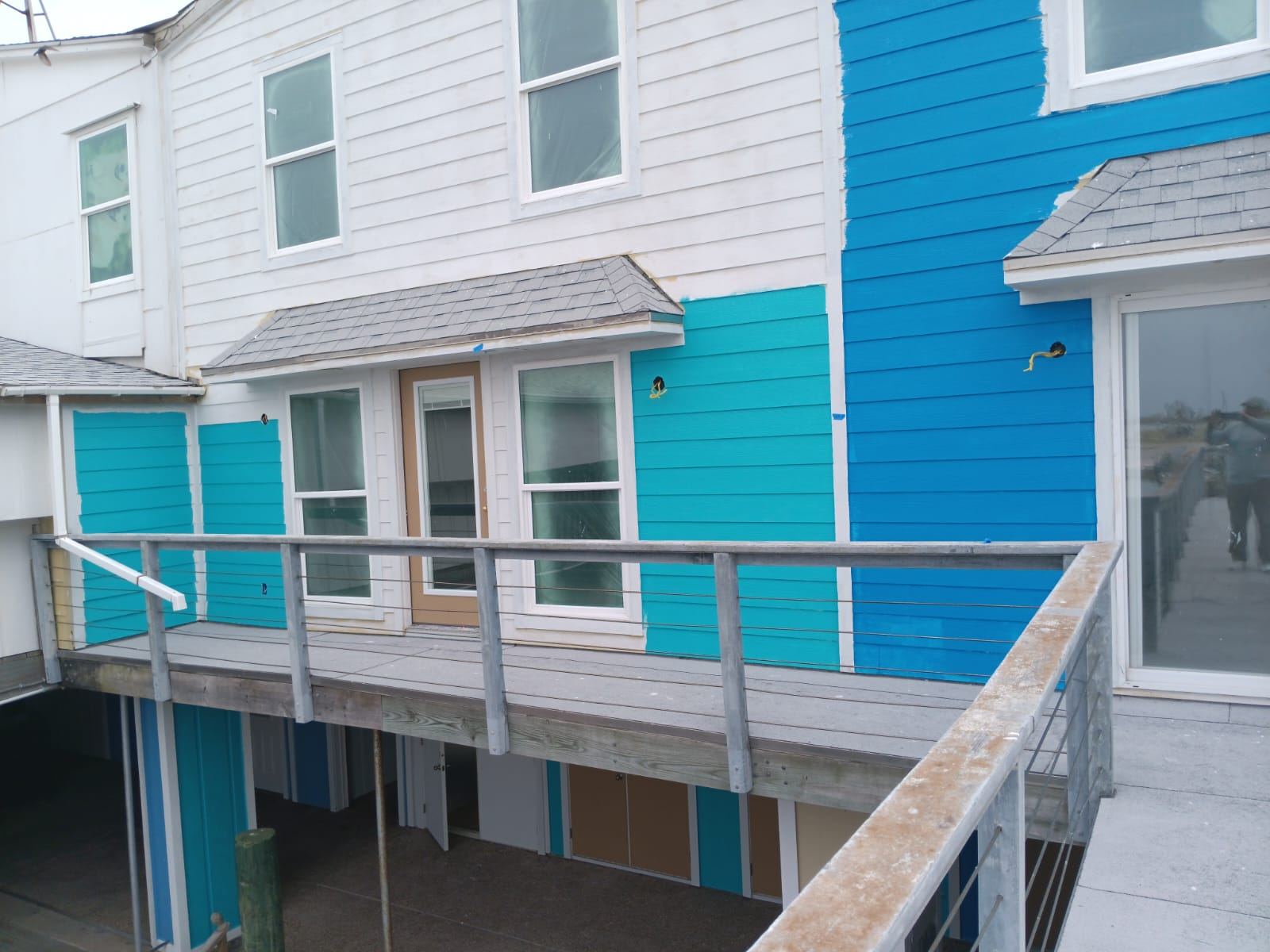 Dark teal three-story coastal home exterior